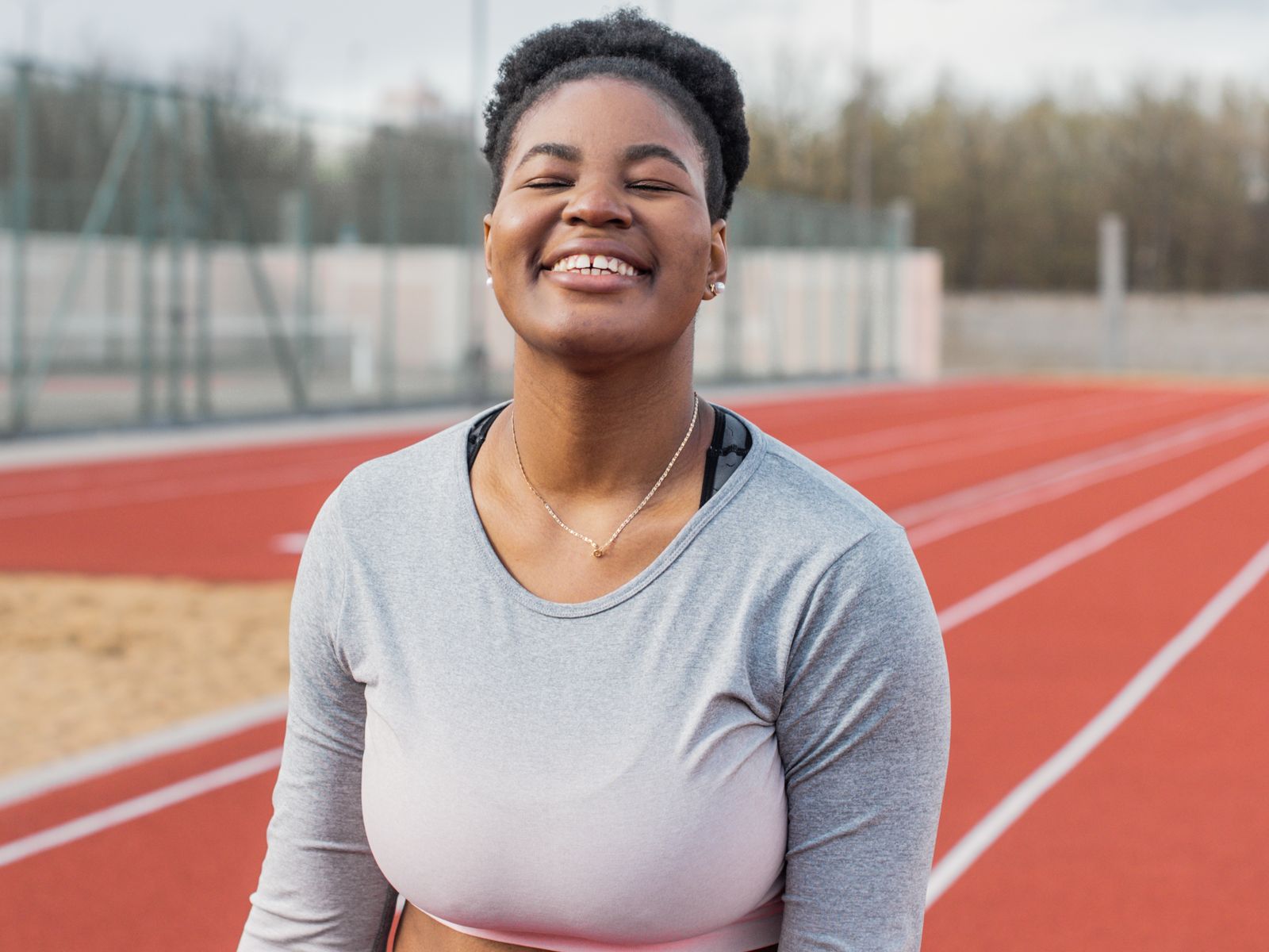 Mulher sorrindo ao ar livre após rotina de exercícios